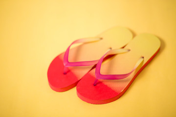 Beach flip flop on yellow background