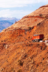 A red truck driving on the mountain road, Yunnan, China.