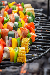 Skewers on grill with vegetables and meat in summer