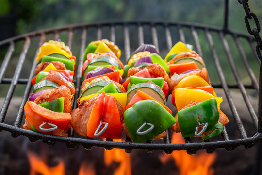 Homemade skewers on grill with meat and vegetables in summer