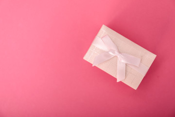 Gift or present box  on pink table upper view. Flat lay composition for birthday, mother day or wedding.