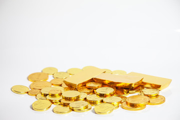 piles of gold coins and gold bar arranged on white background, isolated