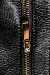 Detail of zipper on black leather. Macro with extremely shallow depth of field.