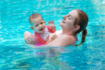Happy little child with mom, First time in a large pool and very impressed. Very happy and frolic.
