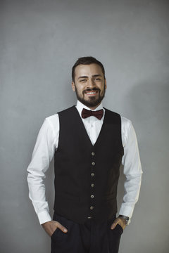 Smiling man in black vest and bow tie