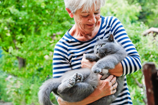 Frau schmust mit Katze auf dem Arm