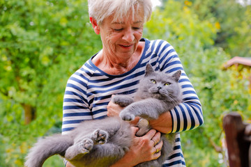 Frau schmust mit Katze auf dem Arm