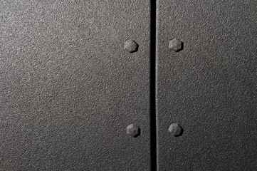 Surface of powerful suv bodywork, side part of car with bolts and black textured paint coating, detail of vehicle 