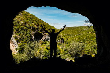 silhouette of a man in a cave in the mountains