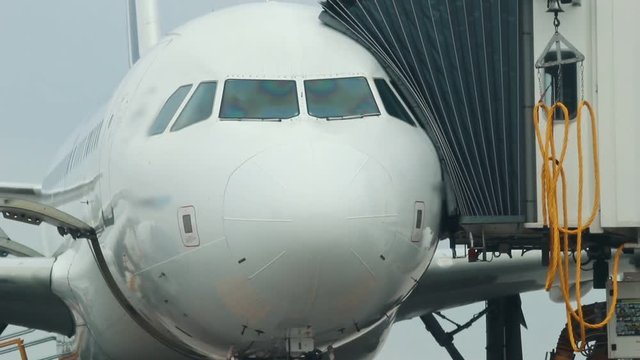 A huge plane standing on the airplane field. A transition pass connected to the enter in the plane