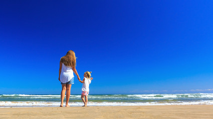 Fototapeta premium Happy mother and daughter spend their holidays on the seashore.