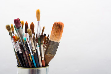 Fototapeta premium bunch of paint brush at tin can, on white wooden