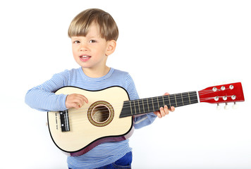 Ein dreijähriger Junge spielt auf einer Gitarre