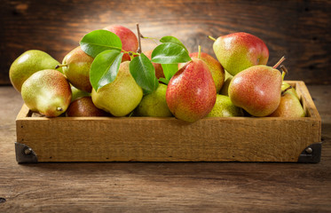 fresh pears in a box on a wooden table