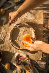 woman in gentle sundress cooking a sweet pie with fresh apricots on a sunny summer day