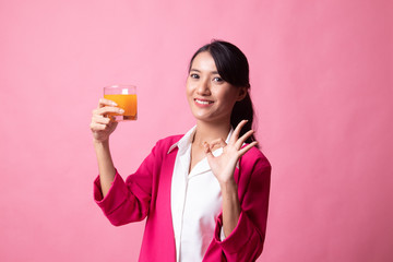 Young Asian woman show OK drink orange juice.