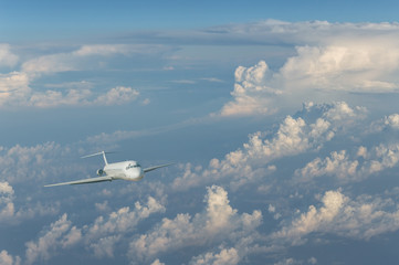 Commercial airplane flying above clouds
