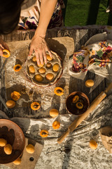woman in gentle sundress cooking a sweet pie with fresh apricots on a sunny summer day