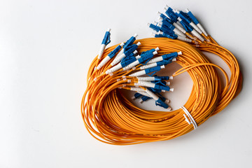 Yellow optical fiber network cable with blue connectors isolated on white background