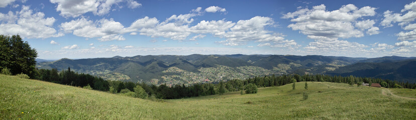 Fototapeta premium Beauty of the nature on Carpathian Mountains landscape: Svinyanka mountain view from the summit to the village Mykulichin. Panorama.