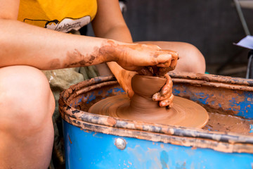 The master behind a potter's wheel with a product from raw unfired clay modeling