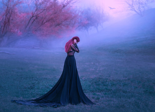 Mustery gothic woman sad lady in black dress unhappy walking in deep forest fog autumn tree forest. Background autumn trees fantasy girl cries. Pink purple hair. Art photo back rear view, no face