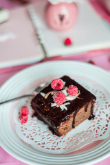 tasty homemade chocolate birthday cake decorated of some raspberries and candles served on the gentle pink background