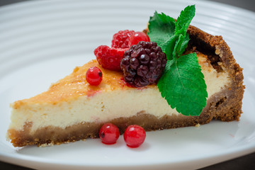 Slice Of Classical New York Cheesecake with berries On White Plate