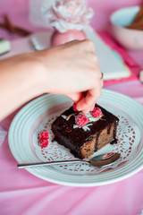 tasty homemade chocolate birthday cake decorated of some raspberries and candles served on the gentle pink background