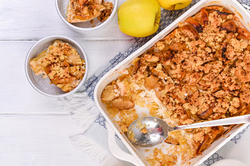 Apple pie in white ceramic baking dish. Homemade breakfast with apples. Bright photo. Free space for text. Flat lay