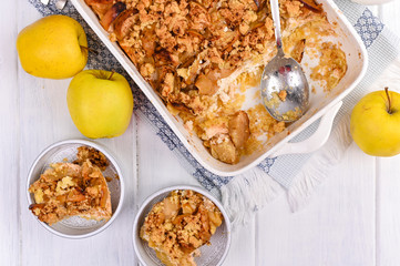 Apple pie in white ceramic baking dish. Homemade breakfast with apples. Bright photo. Free space for text. Flat lay