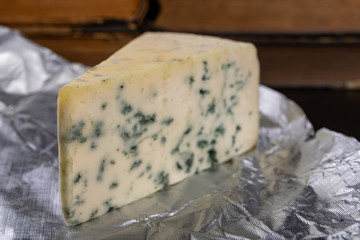 Delicious blue puff cheese on a wooden board. Tasty pleasing cheese prepared for a meal.