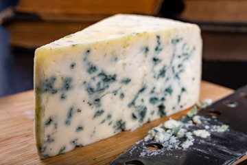 Delicious blue puff cheese on a wooden board. Tasty pleasing cheese prepared for a meal.