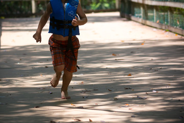 Child Running on Walkway in the Park in a Hot Day