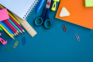 School supplies on blue background. Top view. Copy space.