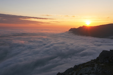 Fototapeta premium beautiful sunset above the clouds in the mountains. stunned landscape background with copy space. aerial mountain view