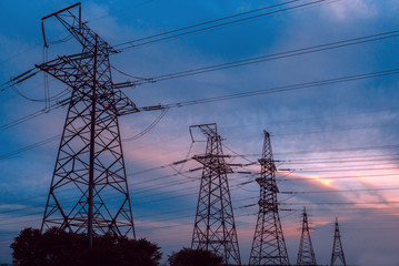  high-voltage power lines at sunset. greeb field.
