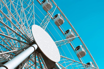 carousel attraction ride white ferris wheel in amusement park in front of blue sky bottom view