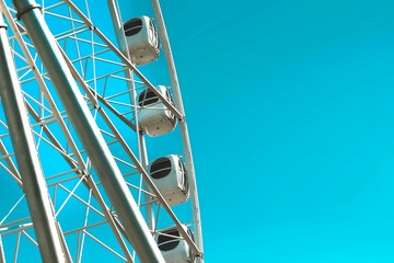 carousel attraction ride white ferris wheel in amusement park in front of blue sky bottom view