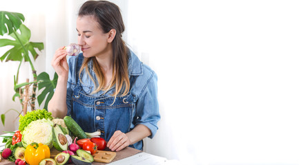 Young and happy woman eating salad at the table