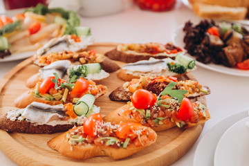 sandwich with trout, cherry tomatoes and lettuce. a plate of snacks.