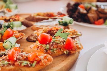 sandwich with trout, cherry tomatoes and lettuce. a plate of snacks.