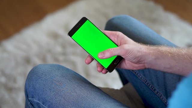 Male hand swiping RIGHT on a phone with a green screen