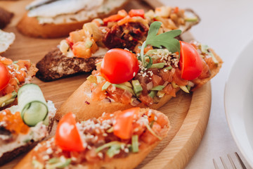 sandwich with trout, cherry tomatoes and lettuce. a plate of snacks.