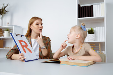 Speech therapy concept. Patient kid with female therapist training pronunciation