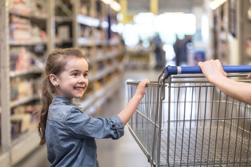 Mother and daughter shopping in supermarket choosing products