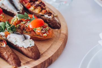 sandwich with trout, cherry tomatoes and lettuce. a plate of snacks.