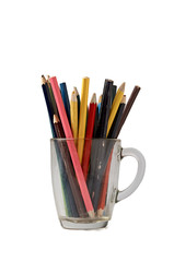 Multi-colored pencils in a transparent glass mug isolated on white