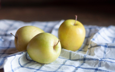 apples, kitchen towel and wooden table