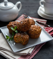 Some carrot muffins with nuts and mint  white cup of tea breakfast bakery